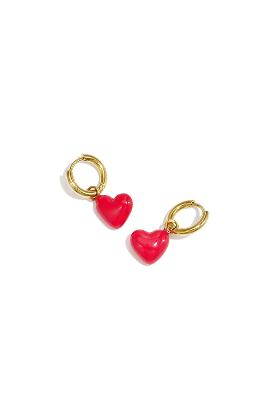 Gold-tone hoop earrings with red glossy heart enamel charms on white background