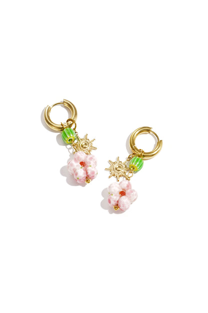 Gold hoop earrings with pink beaded flower, green bead, and sun charm on white background