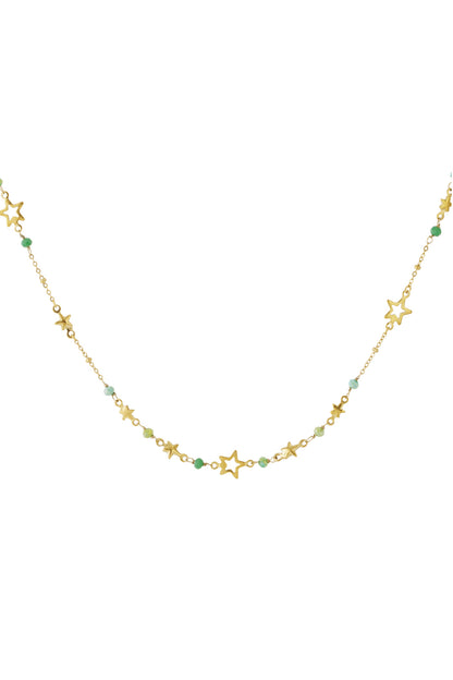 Close-up of gold-toned star charm necklace adorned with alternating green and white beads on a plain white background