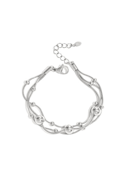 Silver multi-strand chain bracelet with polished round beads and adjustable lobster clasp on white background