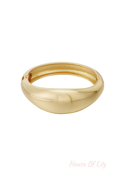 Gold dome-shaped smooth bangle bracelet isolated on white background