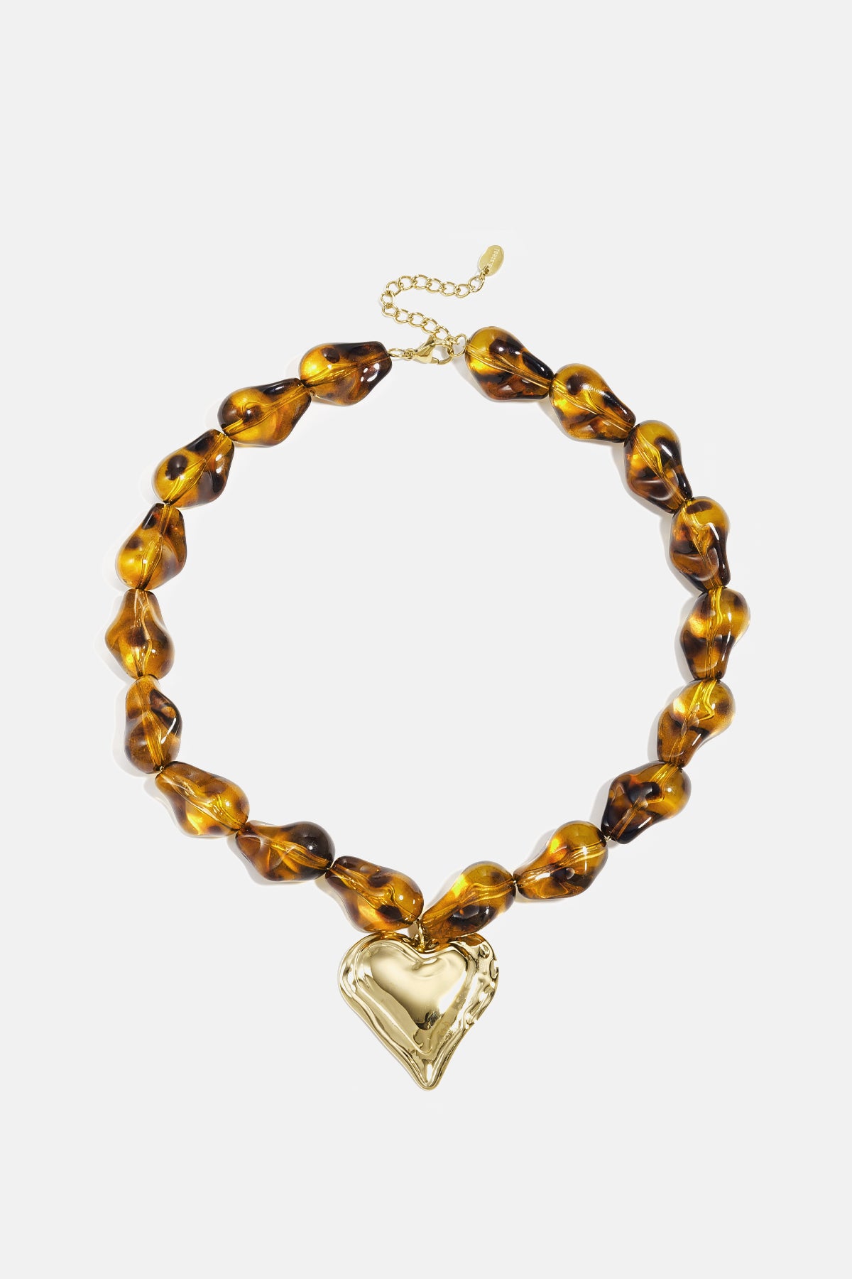 Amber-toned acrylic beaded necklace with gold heart pendant laid flat on white background