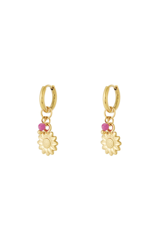 Pair of gold hoop earrings with sunflower charm and small pink bead accents displayed on white background