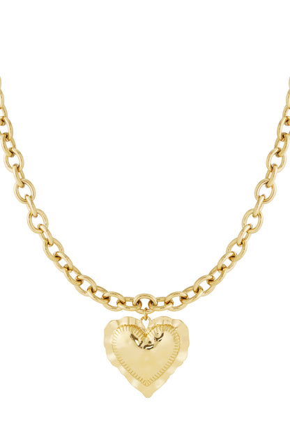 Gold chunky linked chain necklace with textured heart pendant isolated on white background