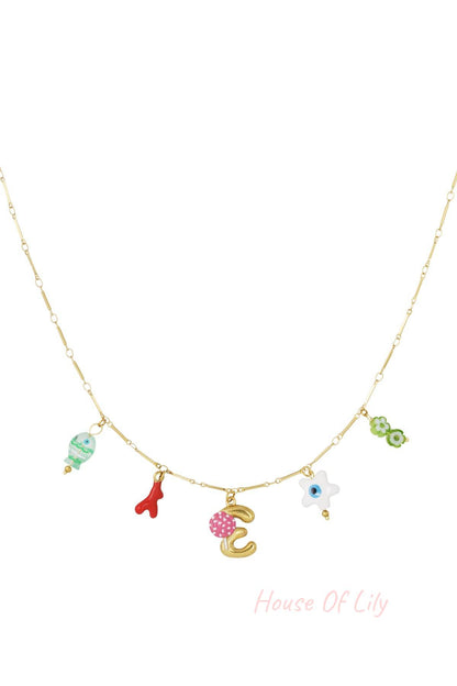 Gold charm necklace with yellow lemon, blue strawberry, white fish, and gold letter G charms