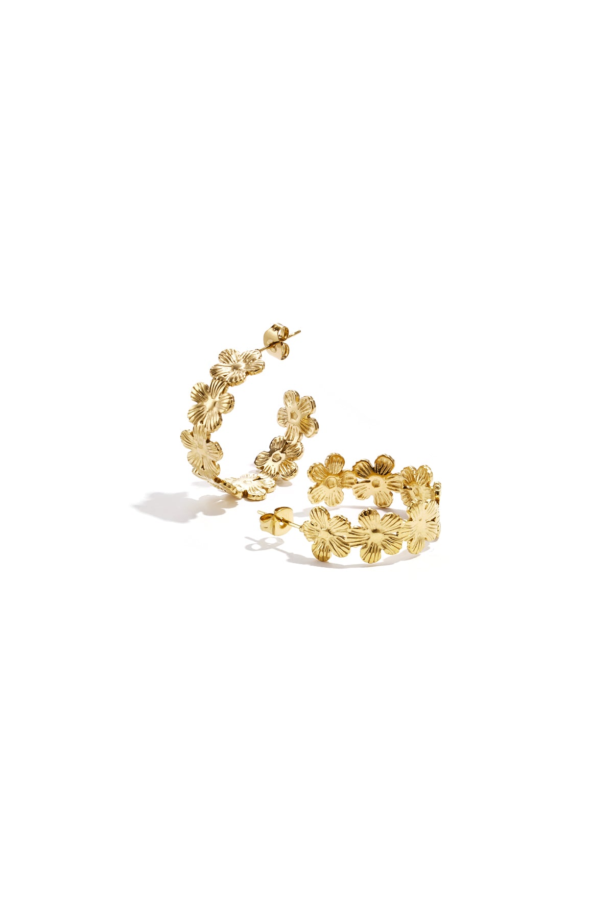 Pair of gold-tone hoop earrings adorned with textured floral motifs on a white background.