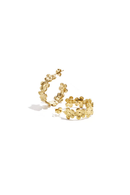 Pair of gold-tone hoop earrings adorned with textured floral motifs on a white background.