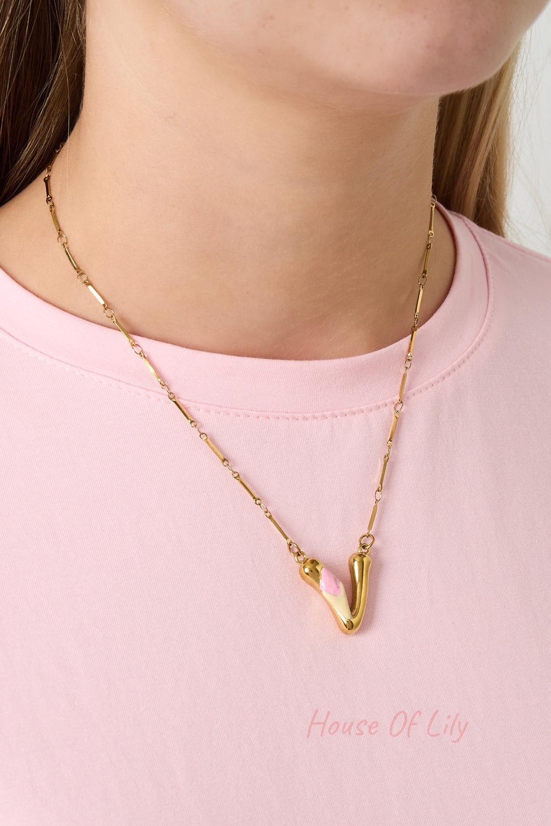 Gold chain necklace with gold seashell, red crescent moon, blue flower charms, white pearl, blue fish charm, and gold letter B with pink flower pendant