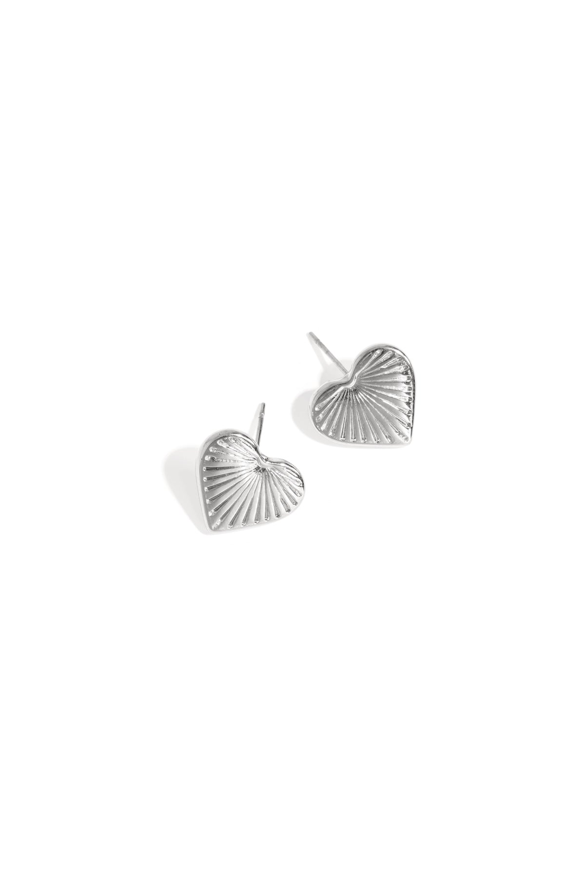 Silver-tone heart-shaped stud earrings with textured sunburst pattern on white background
