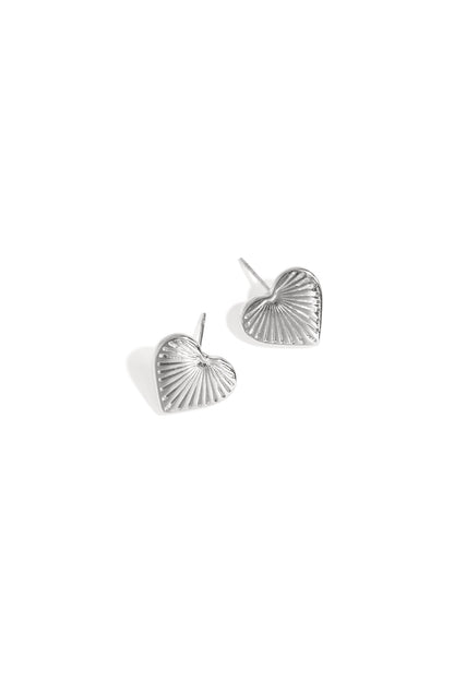 Silver-tone heart-shaped stud earrings with textured sunburst pattern on white background
