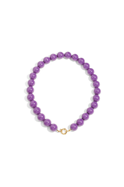 Chunky purple resin bead necklace featuring a gold-toned circular front clasp on a plain white background.
