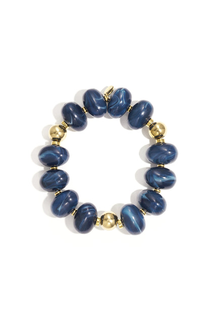 Blue marbled resin beaded bracelet with gold beads on white background