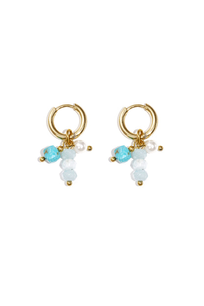 Pair of gold hoop earrings on white background featuring a variant with pale blue and turquoise beads alongside a pearl accent