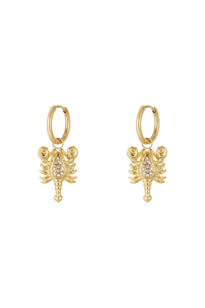 Pair of gold Scorpio charm hoop earrings with rhinestone details on a white background