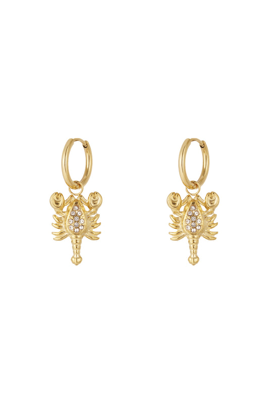 Pair of gold Scorpio charm hoop earrings with rhinestone details on a white background