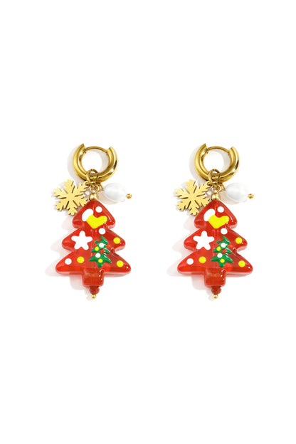 Pair of gold hoop drop earrings with red resin Christmas tree charms decorated in white, yellow, and green, accented with gold snowflake and white bead charms on a white background
