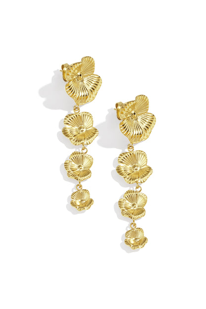 Gold floral cascade dangle earrings laying flat on white background