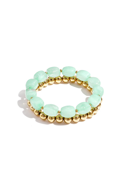 Two stacked bracelets featuring pastel mint green oval beads and polished gold metallic round beads.