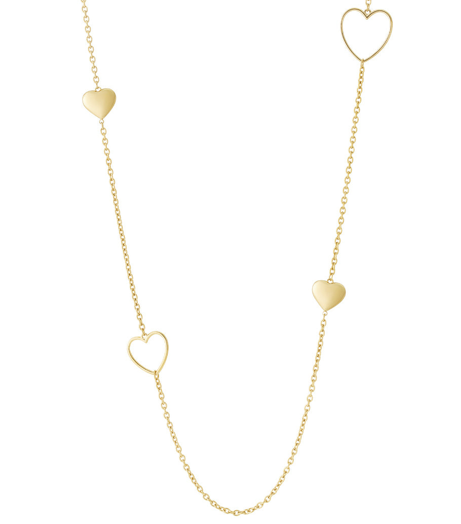 Close-up of a delicate long gold chain necklace with alternating solid and open heart-shaped charms