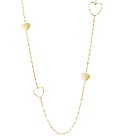 Close-up of a delicate long gold chain necklace with alternating solid and open heart-shaped charms