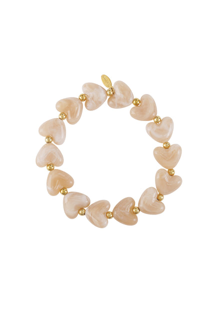 Peach marbled heart beaded stretch bracelet with gold accent beads on white background