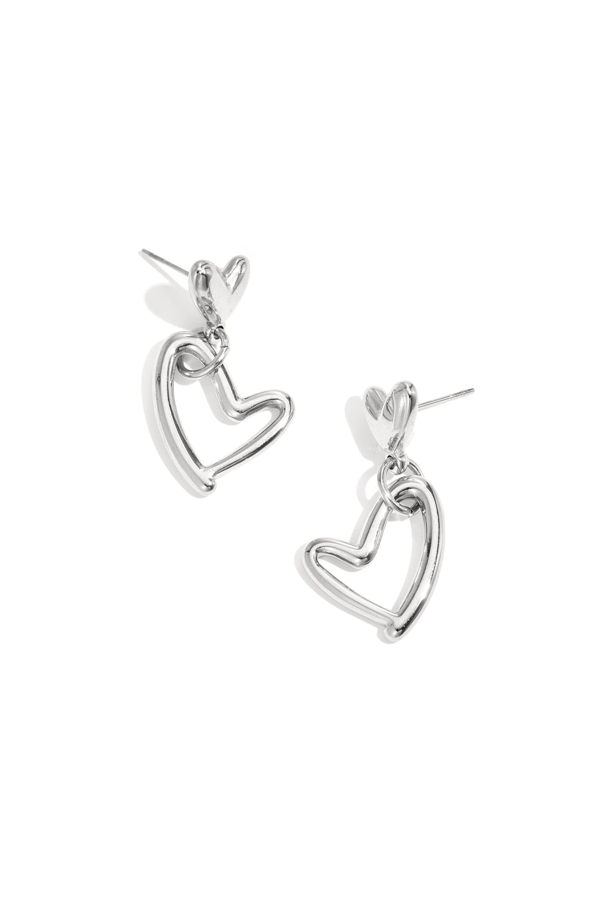 Pair of silver-tone heart-shaped drop earrings with solid heart studs and open heart drop charms on a white background