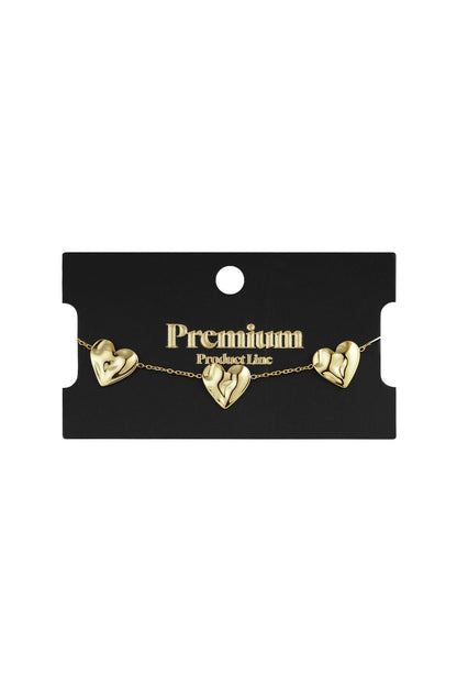 Gold-tone chain bracelet featuring three sculpted, puffed heart charms on a black Premium Product Line display card.