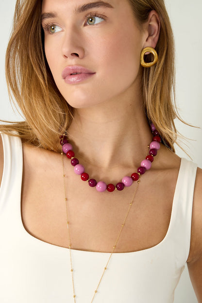Chunky beaded necklace in teal, purple, and brown colors with glossy finish and gold clasp on white background