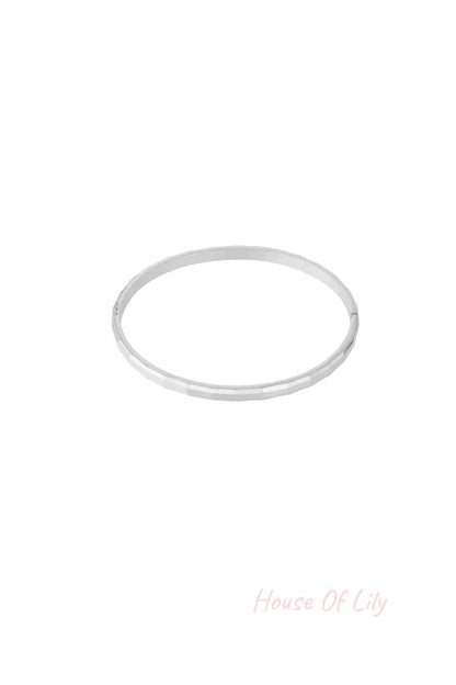 Single geometric faceted silver bangle isolated on white background