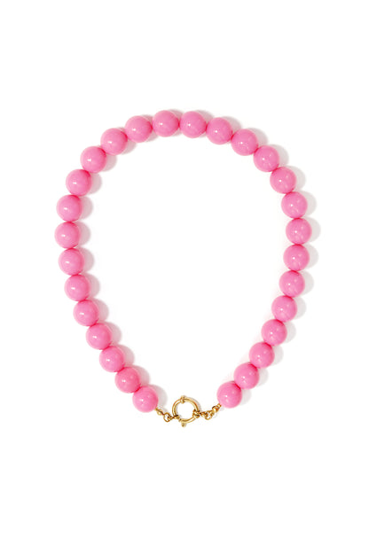 Close-up of chunky pink glossy resin beaded necklace with gold clasp on white background