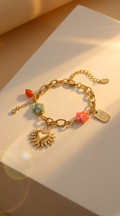 Charm Era Unlocked gold link bracelet with sun-heart pendant, colorful flower charms, and a "Good Luck" tag.