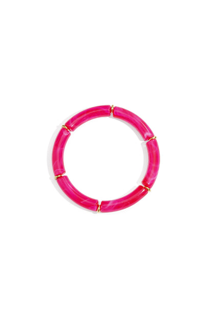 Circular bright pink resin tube bracelet with gold-tone ring spacers on white background