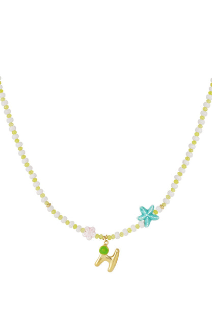 Purple beaded necklace with two turquoise starfish and a gold letter O pendant with a purple shell charm