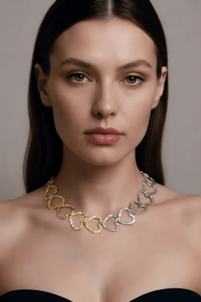 Linked Hearts Energy necklace featuring textured, mixed-metal gold and silver heart links worn by a woman.