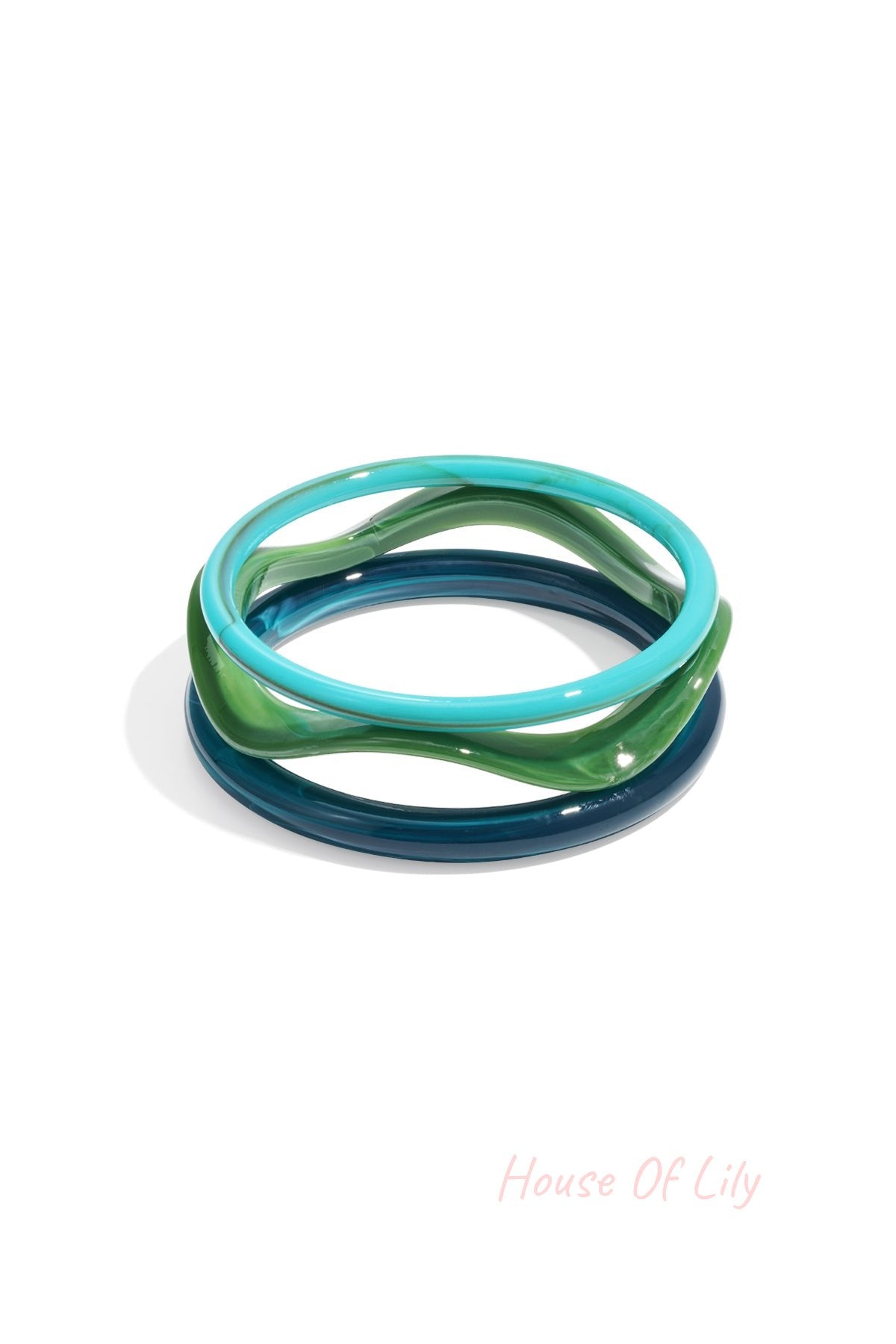 Three acrylic bangles in shades of blue, green, and turquoise with wavy design on white background