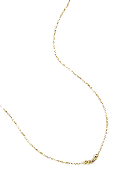 Gold ball chain necklace laid flat on white background displaying chain and five beads