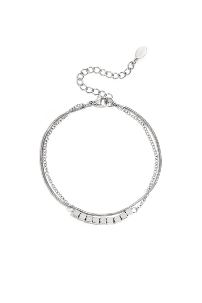 Silver-toned dainty cube chain bracelet with adjustable clasp laid flat on white background