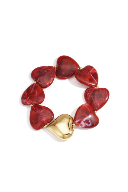 Heart-shaped marbled red acrylic bead bracelet with gold-tone heart accent on white background