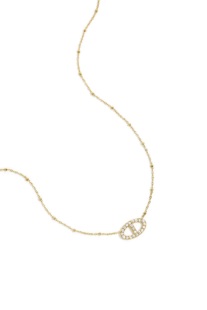 Delicate gold pendant necklace with sparkling crystal-encrusted oval pendant and beaded chain detail on white background