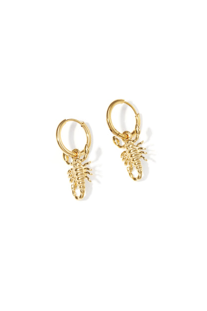 Pair of gold hoop earrings each with a small detailed scorpion charm on a white background