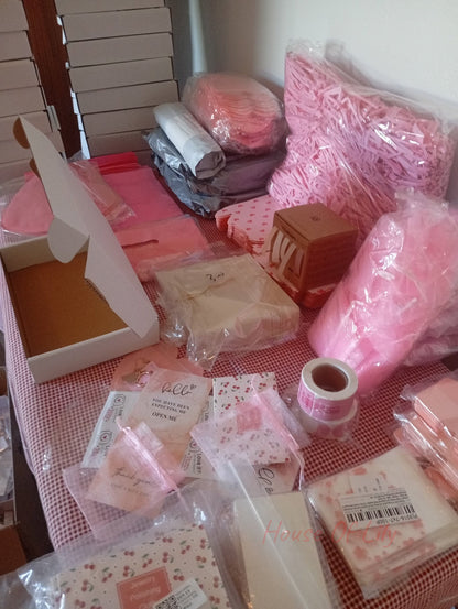 Mystery Box: Launch Edition packaging supplies including pink crinkle paper, boxes, bags, and cards.