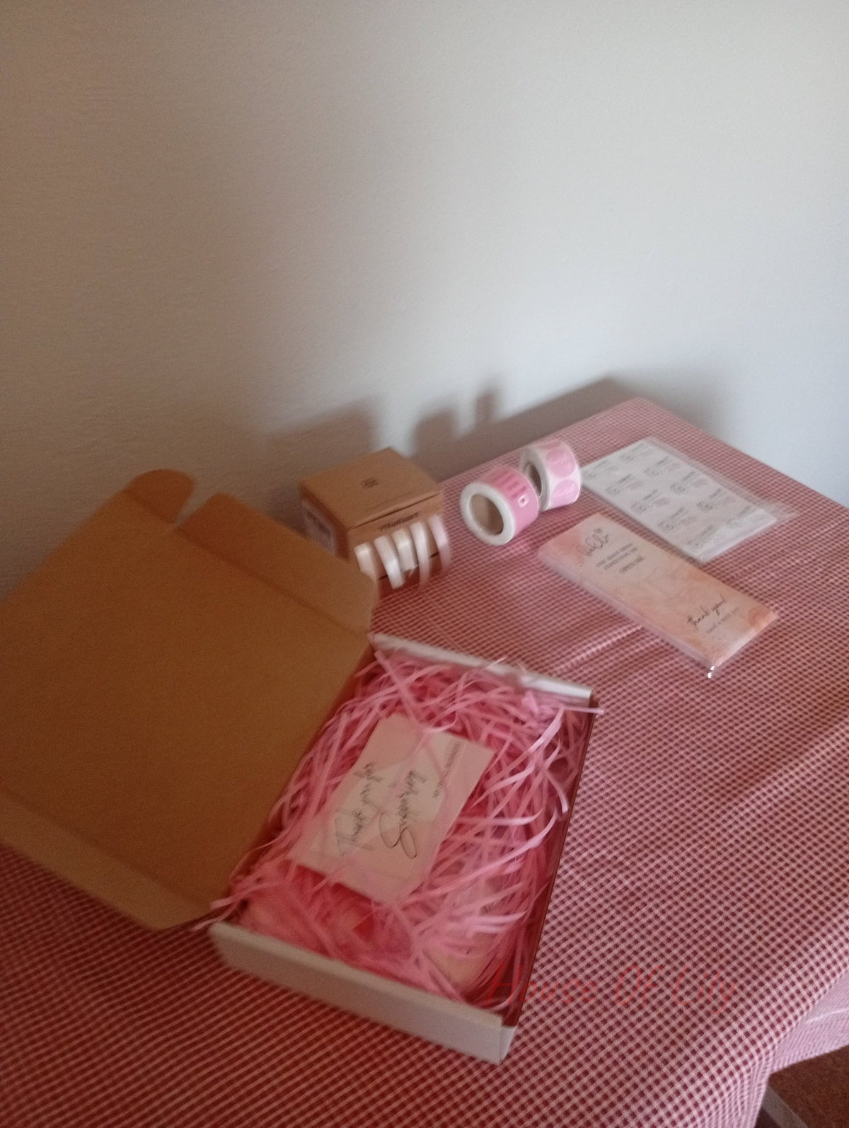 Mystery Box: Launch Edition featuring an open box with pink shredded paper filler and a branded card.