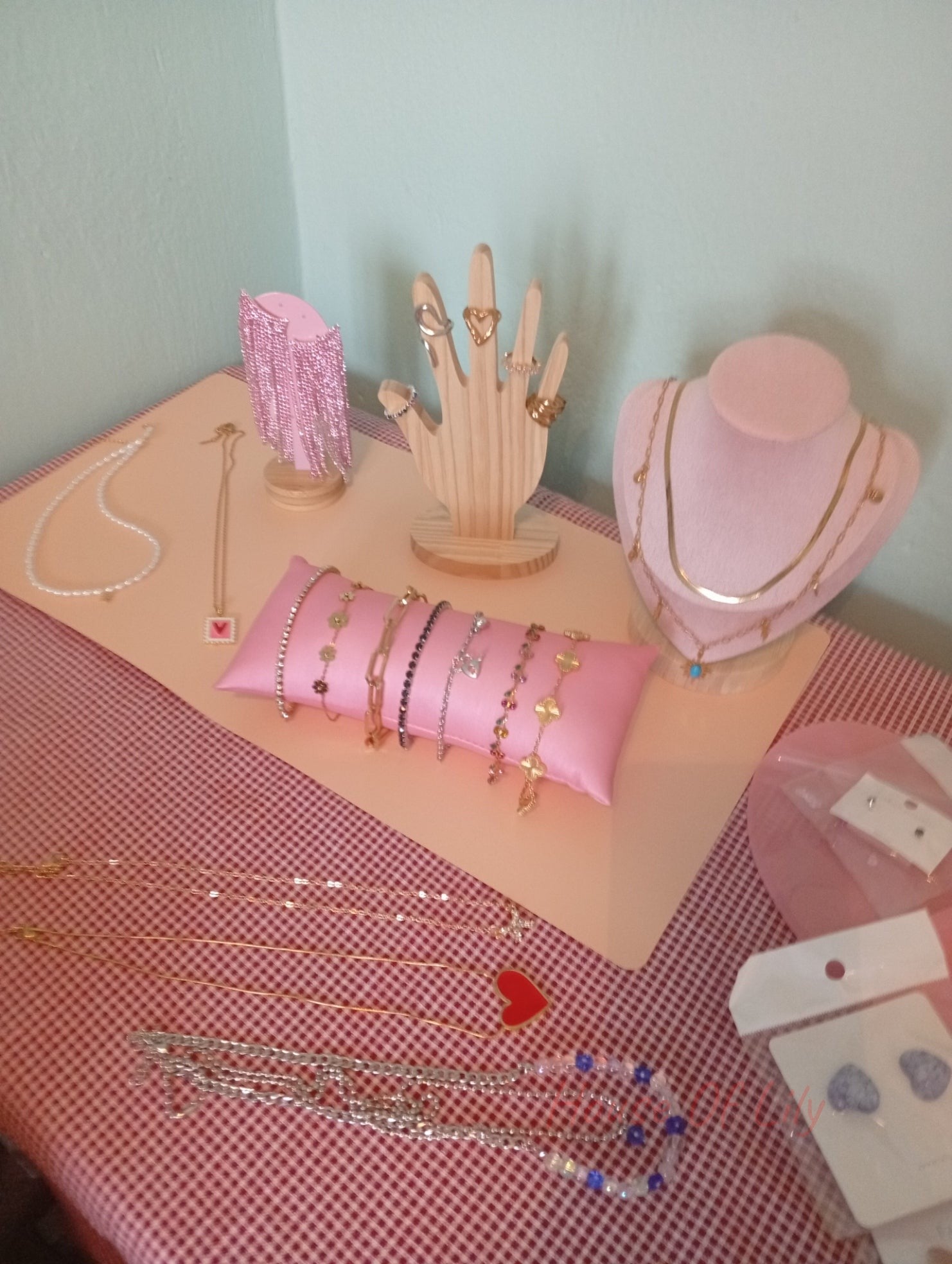 Assortment of gold and silver-tone jewelry including necklaces, bracelets, rings, and earrings on display stands.