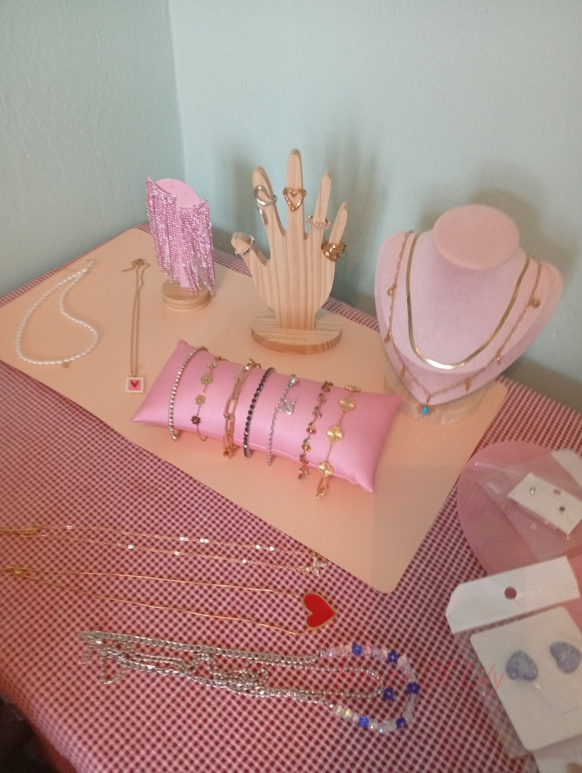 Assortment of gold and silver-tone jewelry including necklaces, bracelets, rings, and earrings on display stands.