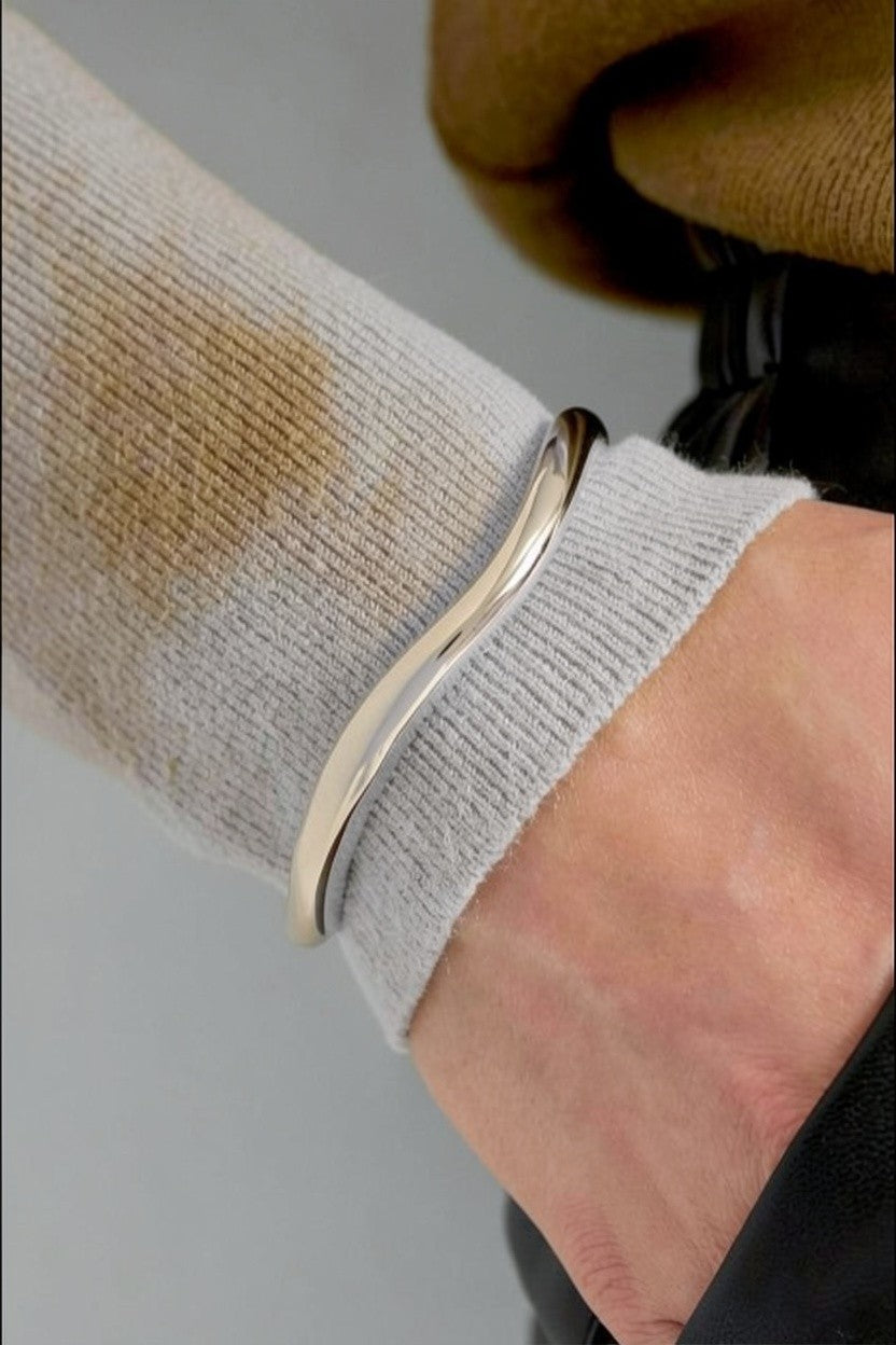 Clean Aesthetic Cuff: A minimalist, polished silver-tone metal cuff with a smooth, fluid, wavy organic shape.