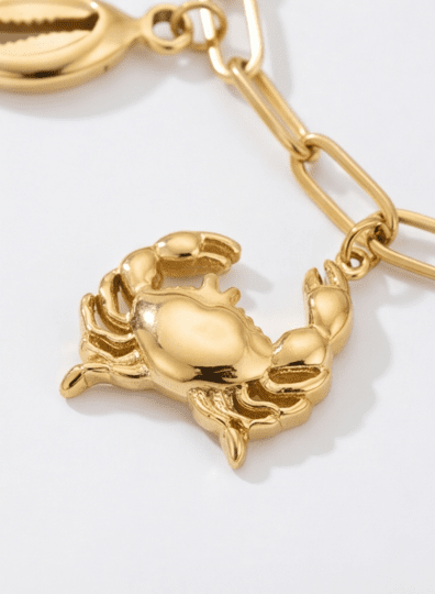 Seaside Charm Bracelet featuring a gold-tone crab pendant on a matching chain link bracelet against a white background.