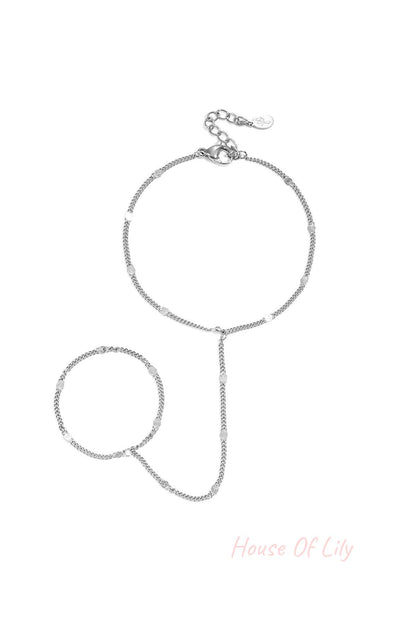 Delicate silver chain hand bracelet with small shimmering discs and adjustable lobster clasp