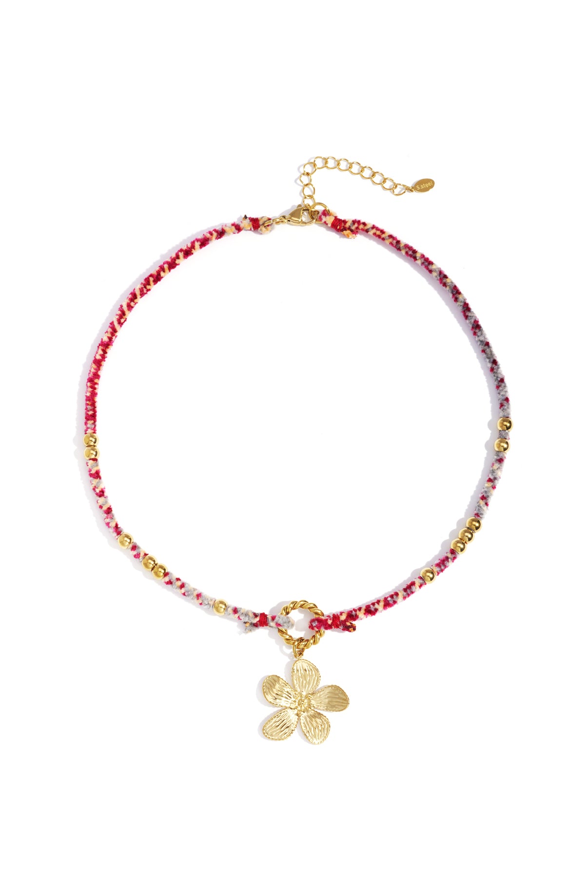 Close-up of a chic floral charm necklace with red and white woven rope, gold beads, and a gold flower pendant on a white background