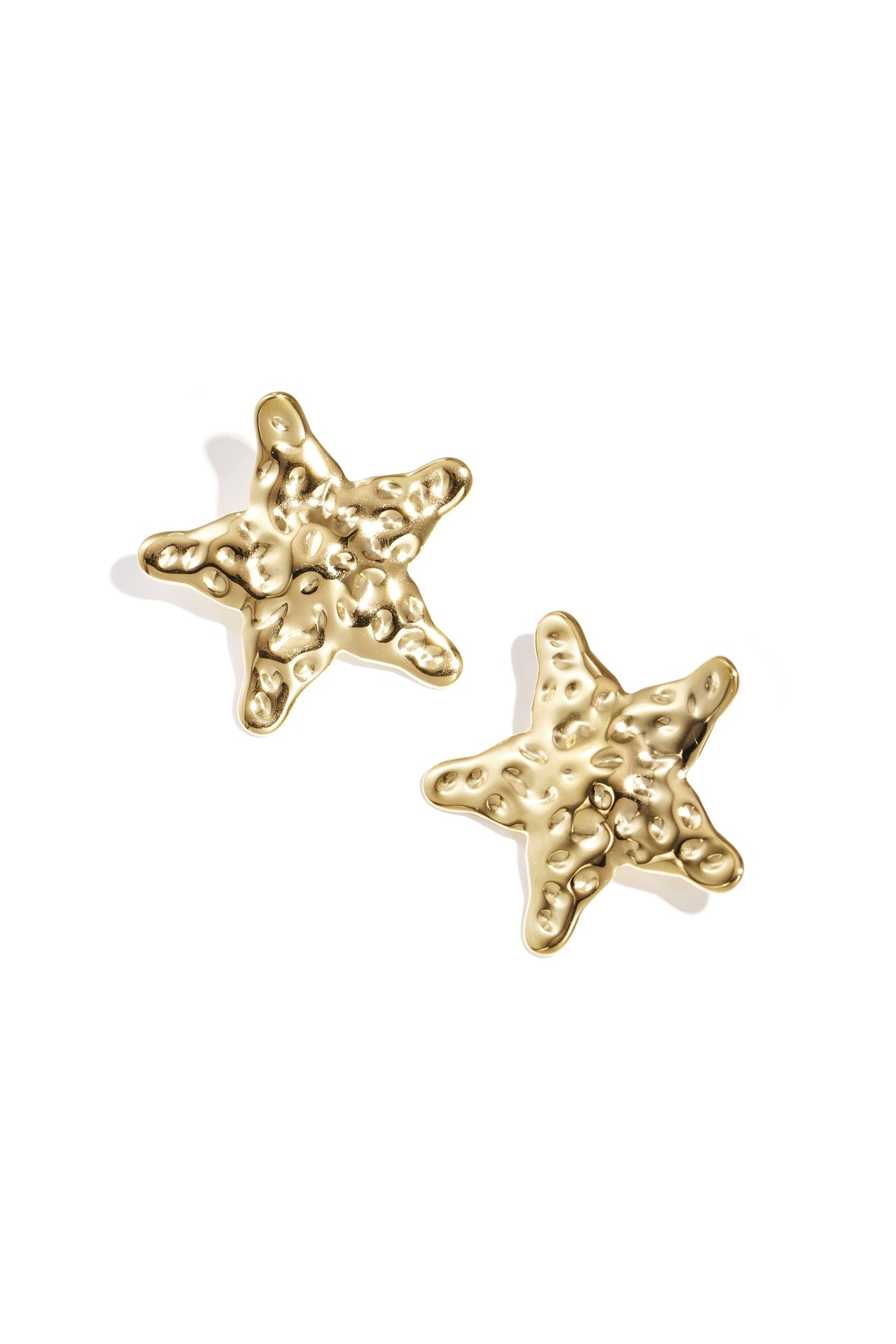 Close-up view of gold textured starfish-shaped stud earrings on white background