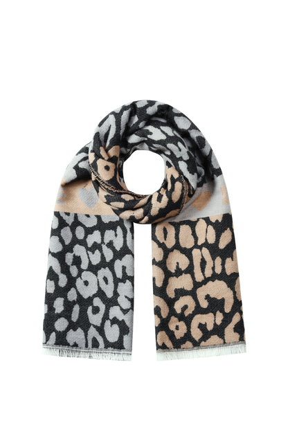 Leopard print scarf in black, beige, and gray tones with fringed edges laid flat